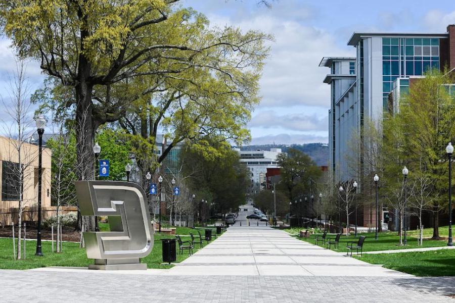 联合技术大学校园内绿树成荫的藤街步行街, 包括不锈钢的“Power C”标志雕塑, 德西克大厅和UTC图书馆, 背景是乌纳姆大楼.